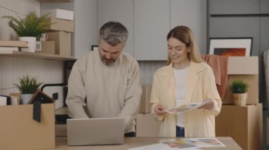 Family Is Choosing Design for Future Interior. Young Couple Choosing Color Palette and Furniture at Home Together Using Laptop. New Home, Relocation, Decoration, Renovation, and Painting Concept