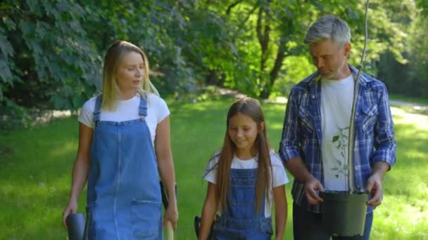 Fröhliche Kaukasische Familie Geht Den Park Gemeinsam Einen Baum Pflanzen — Stockvideo
