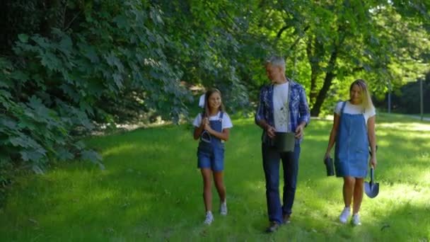 Счастливая Семейная Команда Экологических Активистов Прогуливающаяся Парку Перед Посадкой Деревьев — стоковое видео
