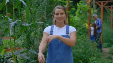 Gülümseyen beyaz kadın çiftçinin portresi. Çiftlikte durmuş ellerini çapraz yapıyor. Çiftlikteki Güzel İşçi Kameraya Bakıyor. Tarım İş Konsepti