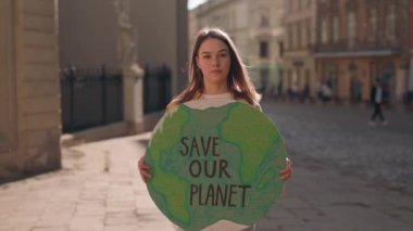 Şehir Caddesinde Duran ve Gezegen Ekoloji Posterimizi Kurtaran Kadın Eylemci. Çevre Kirliliğine Karşı Tek Protesto. Küresel Isınmaya Karşı Gönüllü Protesto, Dünya Günü