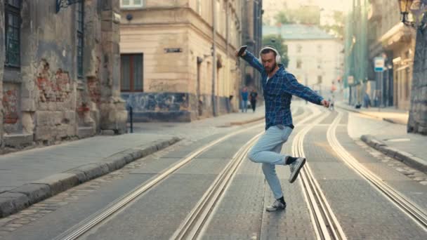 Zabawny Biały Hipster Tourist Man Zakłada Słuchawki Tańczy Muzyki Świeżym — Wideo stockowe