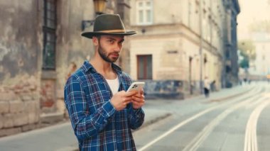 Yurtdışında Eğlence Tatili ya da Tatil İçin Telefon Kullanan Adamın Portresi. İnternet ve GPS talimatları olan yakışıklı bir erkek kullanıcı. Gezgin Kameraya Bakıyor