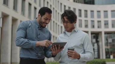 Haberler iyi. Mutlu Gülümseyen İş Arkadaşları Tableti Açık havada Kullanıyor. Sürpriz iş adamları dışarıda zaferi kutluyorlar. Kazanma Konsepti