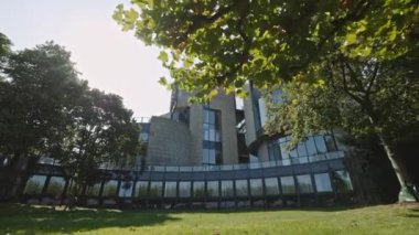 DÜZSELDORF, ALMANY - 1 Temmuz 2021: Düsseldorf, Almanya 'daki Camsı İş Binası. Harika bir yaz günü. Mimarlık konsepti. Lüks bina modern parkın yanındaki caddede duruyor.