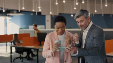 Ofis çalışanları Smartphone 'da spor maçı izleyip favori takımlarını destekliyor. Heyecanlı Çok Irklı Erkek ve Kadın İş Meslektaşları Bir Hedefi, Bahsi veya Piyango Kazananını Kutluyor