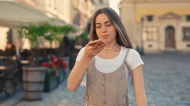 Modern Smartphone 'da Açık havada yürürken mikrofonla konuşan rahat giyimli güzel bayan. Beyaz kız tek başına yürüyor, cep telefonu asistanını aktifleştiriyor. Sesli Mesaj