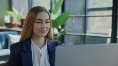 Ofiste oturan ve bilgisayar üzerinde çalışan genç, çekici kadın çalışanın yakın görüntüsü. Girişimci Bayan Aranan Stajyer, Ofiste Çevrimiçi İş Yapıyor. Kapat.