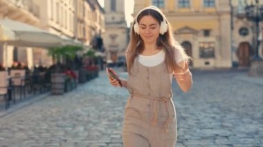 Neşeli, stil sahibi, kulaklıkla gezen, şehir merkezinde dans eden, müzik dinleyen, eğlenen, dışarıda gezen çekici bir gezgin. Neşeli Bayan Çılgın Dansçı, Dışarıda eğleniyor