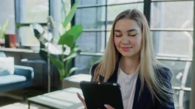 Yakın görüş. Pozitif Güzel Girişimci Ofiste otururken Dijital Tablet kullanıyor. Mutlu Kız İnternet Taraması, Çalışırken Tablet Mesajlaşması.