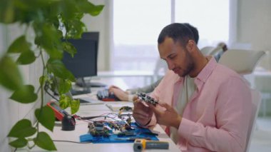 Gömülü Sistem Programcısı. Dev Usta, Elektronik Tahtayı Kontrol Ediyor ve Elektrik Ölçümleri Yapıyor. Multimetre Ölçme Cihazı kullanılıyor. Man Holding Anakart