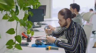 Lehim Teknisyeni, ana kartı tamir etmeye çalışıyor. Aletleri kullanıyor, ofiste oturuyor. Laboratuvarda Mühendis Masa Lehim Demir Devre Kurulu 'nun yanında oturuyor. Teknik Onarım, Araştırma Ofisi