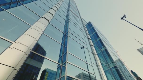 暖かい春の日に新しいオフィスガラス高層ビル ブルースカイに対抗する壁ミラービルでビジネス地区をイメージ ロービュー — ストック動画
