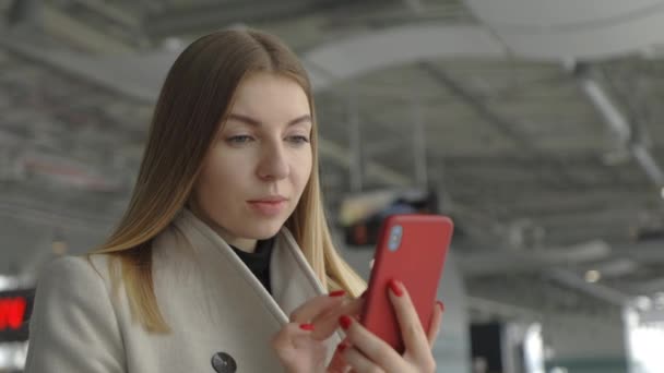 站在机场的女旅客 使用手机 上网工作 发短信与客户 滚动应用程序 女性在机场与电话 旅游及科技概念 — 图库视频影像