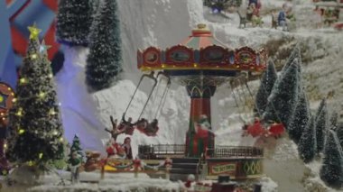 TURIN, İtalya - 12 Aralık 2021: vitrinde duran atlıkarınca oyuncağının şirin modeli. Eski bir atlıkarıncanın oyuncak kopyası. Beyaz karlı atlıkarıncalı klasik oyuncakçı. Noel konsepti