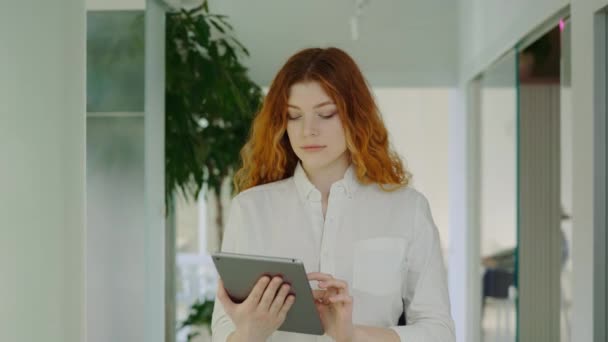 Rødhåret Forretningskvinde Går Ind Kontoret Ved Hjælp Tablet Til Arbejdsformål – Stock-video