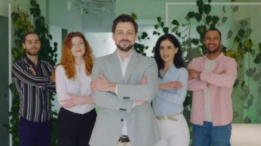 Ofiste Çok Irklı Şirket Personeli Ayakta Duruyor ve Çapraz Eller İçerde. Başarılı Karışık İşçiler Ekibi ve Patronu Kameraya Bakıyor ve Gülümsüyor. Şirket Grup Portresi Konsepti