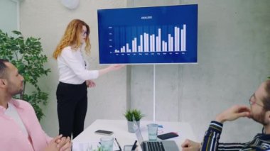 Kurumsal Toplantı Odası 'nda Bayan Yönetici Dijital İnteraktif Whiteboard' u Yöneticiler, Avukatlar ve Yatırımcılar Kurulu 'na sunum için kullanıyor. Herkes tezahürat ve alkış yapsın. Ekran Büyüme Verilerini Gösterir