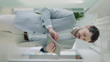 Ofisteyken Dijital Tablet kullanan Kafkas İşadamının dikey Görüntü Portresi. Modern Şirket Ofisi 'ndeki Pad Bilgisayar Teknolojisi' nde çalışan Olumlu İşçi