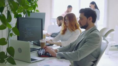 Veri Merkezi Kontrol Odası 'ndaki Masaüstü Bilgisayarları' nda çalışan genç beyaz bilişim programcısı. Modern Ofiste Sofistike Programlama Kodu Dili üzerine Profesyonel İşçi Yazıyor. İnternet Teknolojisi