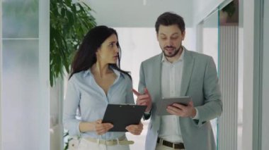 Yakışıklı erkek patron bayan asistanıyla konuşuyor, yeni projesini tartışıyor. Şirket Binası Koridorunda Yürüyen İş Arkadaşları