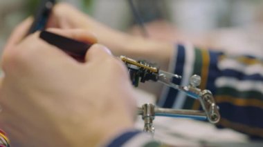 Modern ekipmanlarla Yüksek Teknoloji Araştırma Laboratuvarı 'nda bir devre tahtası lehimliyorum. İşçi Anakart Tamir Aletleri Kullanıyor. Teknik Onarım, Araştırma Ofisi. Kapat.