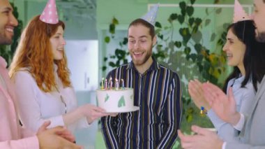Ofiste doğum gününü kutlayan heyecanlı adam kutlu olsun. Doğum günün kutlu olsun. Pastadaki Mumları Üfleyen Adam. Sürpriz ve Ekip Kutlaması. Kafkas Yakışıklı Mutlu Patron İş Arkadaşları Şirketi 'nde.