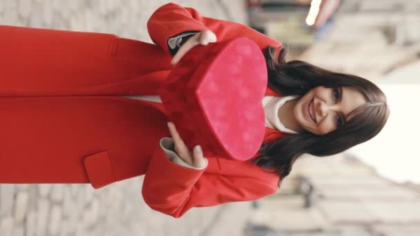 垂直录像 快乐的女人正在为情人节 生日或结婚纪念日准备红礼盒 站在街上展示情人节礼物的黑发女子的画像 — 图库视频影像