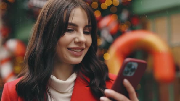 Donna Caucasica Piedi Inverno Decorare Strada Mentre Nevica Utilizzando Smartphone — Video Stock