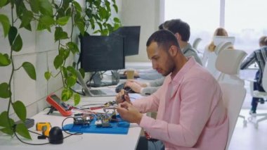 Çok Irklı Yakışıklı Adam Mühendis Çözümleyiciler Ofiste Ana Kart 'ın Parçaları, Devreleri Tamir, Çip veya Tahtayı Kontrol Ediyor. Bilgisayar Donanım Servisinin Bakım ve Onarımı Konsepti