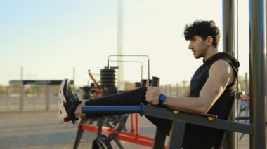 Spor Kafkasyalı Adam Spor Salonunda Beden Eğitimi Makinesinde Fiziksel Egzersiz Yapıyor. Genç Yakışıklı Atletin Bacaklarını Kaldırması ve Karın Kasları Germesi Sağlıklı Yaşam Tarzı ve Spor Aktiviteleri