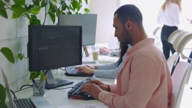 Ofiste Kod Yazan Çoklu Etnik Bilgisayar Programcısı. Guy Yazılım Geliştiricisi bir dizüstü bilgisayarda oturuyor ve çalışıyor. Bir teknoloji şirketinde çalışan yaratıcı bir iş adamı.