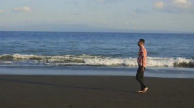 Turist Sahilde Barışçıl Yürüyüş Yapıyor, Akıllı Telefonu Elde Tutuyor, Arkadaşlarla Mesajlaşıyor, Uygulamaları Kaydırıyor. Yakışıklı Gezgin En Sevdiği Sosyal Medya Uygulamalarına Bakıyor