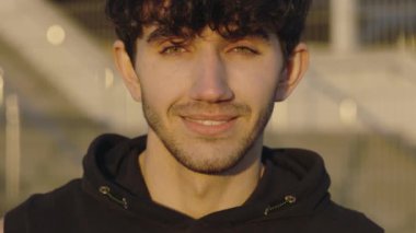 Genç Sakallı Yakışıklı Adam 'ın Spor Eğitiminden Sonra Kameraya Bakan Portresi. Pozitif Adam Koşucusu dışarıda bekliyor. Halk ve Spor Konsepti