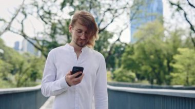 Yakışıklı Sakallı Adam Dışarı Çıkıyor, Mesajlaşmak, E- postaları Kontrol Etmek, Çevrimiçi Sohbetlere Girmek ve Sosyal Medya 'yı Tarayarak Akıllı Telefonunu Ustaca Kullanıyor. İş İnsanları ve Teknoloji Konsepti