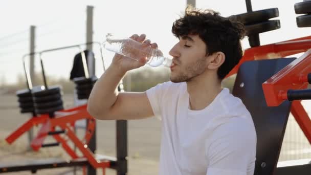 Homem Atraente Caucasiano Sentado Livre Dia Ensolarado Refresca Bebendo Água — Vídeo de Stock