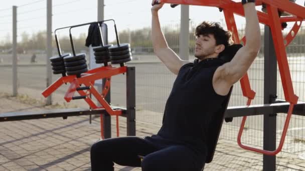 남자는 강렬한 운동에 기계에 무게를 근육을 타겟팅 빌딩에 열정에 사람들과 — 비디오