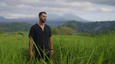 Dışarıdaki Yakışıklı Pozitif Adam 'ın portresi, Dağlarda Poz Veren Arkaplan. Genç Turist, Çimlerde Poz Veriyor. Turizm ve Seyahat Konsepti