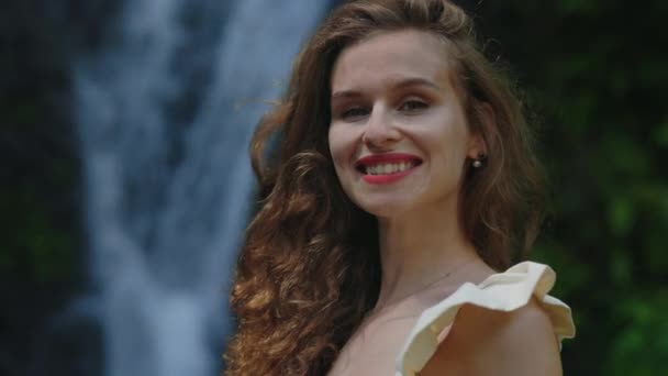 Portret Uśmiechniętej Tropikalnej Kobiety Czerwonymi Ustami Stojącej Tle Wodospadu Długowłosa — Wideo stockowe