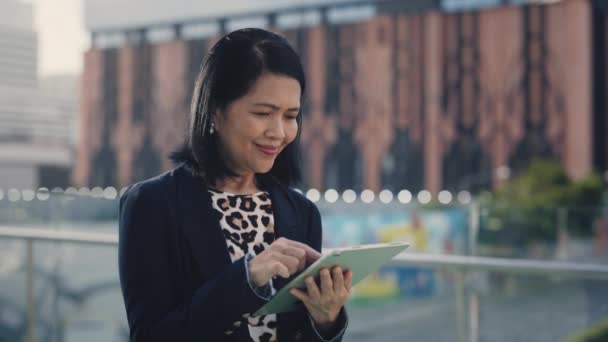 Positive Asian Lady Using Tablet Texting Clients Charming Smiling Senior — Stock Video
