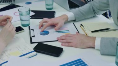 Business Group Kâğıt Defteri Çizelgeleri ve Grafikleri Tartışıyor. Yakın çekim. Yatırımların Açıklaması. İş Analizi ve Strateji Konsepti