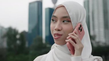 Dışarıda dikilirken bir telefon görüşmesi yapan güzel bir Arap kadını. Geleneksel giysiler içinde, cep telefonuyla iletişim kuran pozitif Müslüman kız. Halk ve Teknoloji