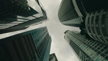 Yüksek camlı gökdelenlerin alçak görüntüsü. Aşağıdaki iş yapılarına dönüşümlü bir açıyla bakmak. Finansal bölge. Şirket mimarisi ve altyapı kavramı.