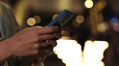 Girl Hands Holding Phone, dışarıda mesajlaşma, internette gezinme. İnternet Uygulamalarında Cep Telefonu Kullanan Kadın Dışarıda Telefonla. Halk ve Teknoloji Konsepti