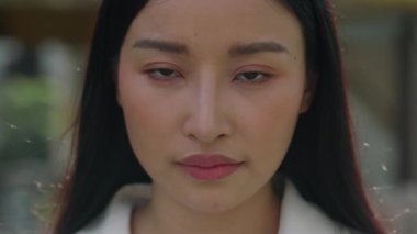 Makyaj Yüzlü Ciddi Bir Kadının Portresi. Asyalı Kadın üzgün bir bakışla doğrudan kameraya bakar. Yakın Çekim Görünümü.