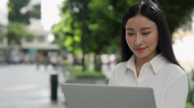 Güzel Genç Kadın Oturuyor, Bilgisayar Kullanıyor, Makaleler okuyor ve Ekrana Gülümsüyor. Dizüstü bilgisayarda çalışan, sokakta oturan inanılmaz yakışıklı bir öğretmen. Halk ve Teknoloji Konsepti