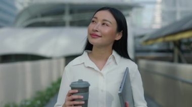 Güzel Kadın Bir Daire Aldı ve Kendi Mahallesini Keşfederken Belgeleri Taşıyor. Güzel pozitif iş kadını Sokakta yürüyor ve kahvenin tadını çıkarıyor.