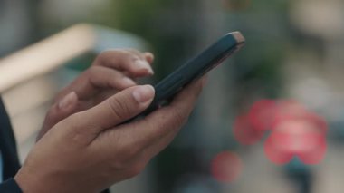 Bir Kadın Elinin Kapalı Çekimi Dışarıda Bir Telefonu Tutarken ve Fotoğraflar ve Videolar Arasında Kaydırırken. Smartphone 'u olan genç bir kadın internette ve sosyal medyada geziniyor. Halk ve Teknoloji Konsepti