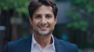 Genç koç sokakta dikilirken kameraya gülümsüyor. Dışarıdan Takım Elbiseli Yakışıklı Bir Erkek Yöneticinin Portresi. Halk ve İş Konsepti