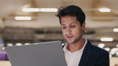 Genç bilişim işçisi Lounge Zone 'da otururken dizüstü bilgisayar kullanarak kod yazıyor. Yakışıklı Sakallı Adam Laptop Mesajı Kullanıyor Dostça İletişim Keyifli. Modern Teknoloji, İnternet ve İnsanlar Konsepti